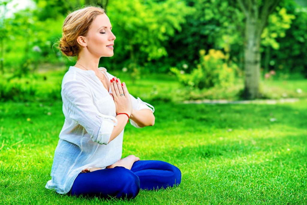 Woman practicing meditation out in nature